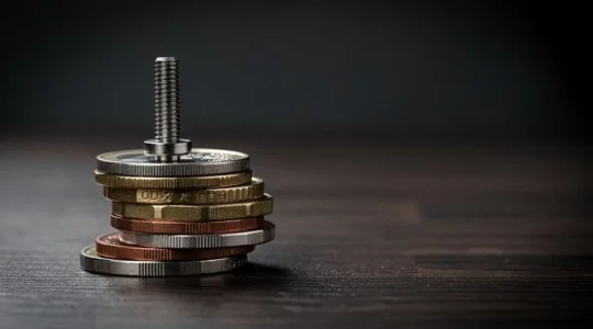 Vis d'implant dentaire en titane posée sur une pile de pièces de monnaie, symbolisant le coût élevé et le vide de remboursement de la Sécurité sociale
