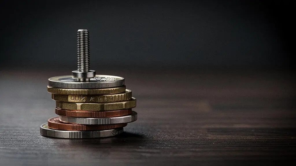 Vis d'implant dentaire en titane posée sur une pile de pièces de monnaie, symbolisant le coût élevé et le vide de remboursement de la Sécurité sociale